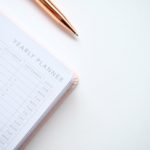 close up photo of yearly planner beside a pen